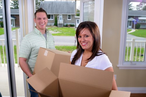 Professional house removalists in Brent loading moving boxes into a van