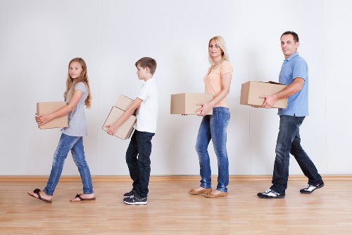Movers loading household boxes for urgent removals in Brent